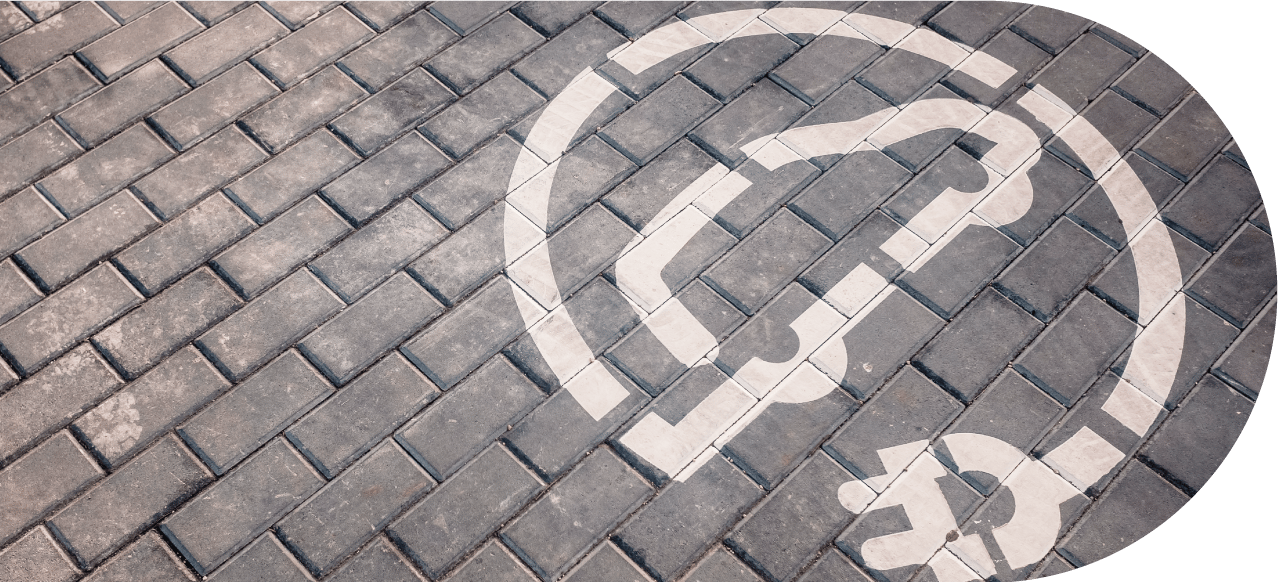 icon of an electric car painted on a brick floor