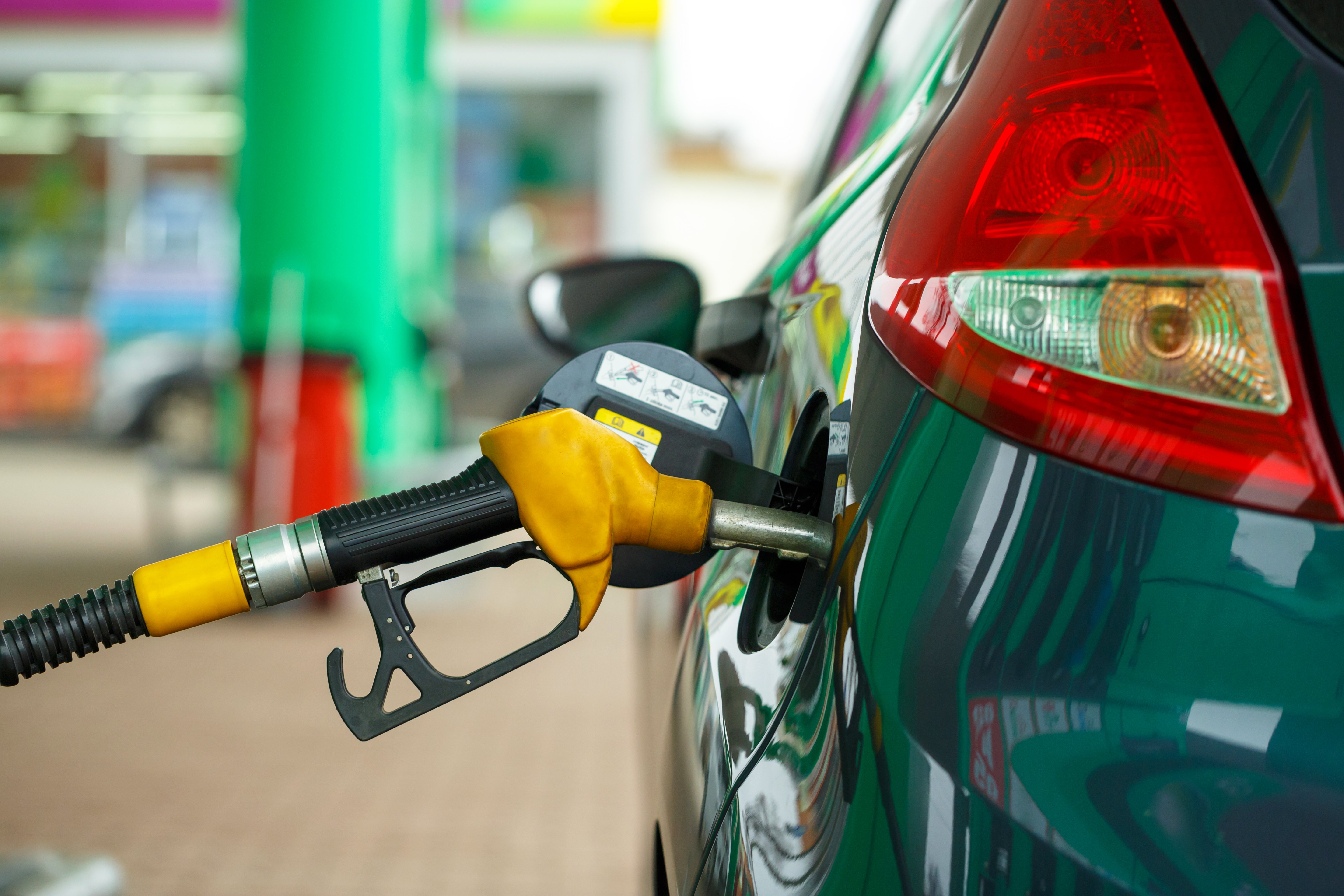 green car at a fueling station